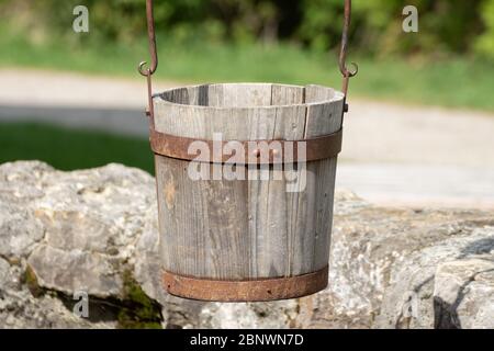 Close up of a old antique wooden bucket hanging over a well Stock Photo