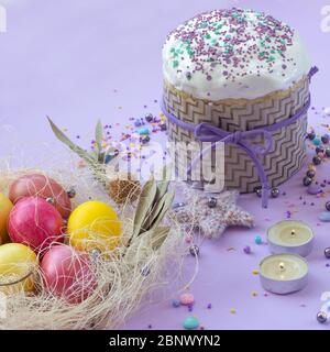 Easter cake and painted eggs beautifully decorated on a lilac background Stock Photo
