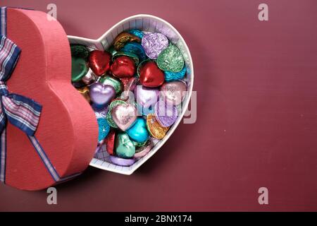 Top view of candy in a heart shape gift box on red background  Stock Photo