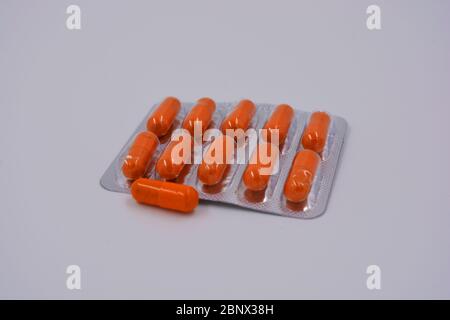 Medical preparations, medical pills in an orange capsule are located on a black background. Stock Photo