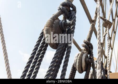 Closeup of block and tackle, wrapped rope and rigging detail on an old sailing ship, horizontal aspect Stock Photo