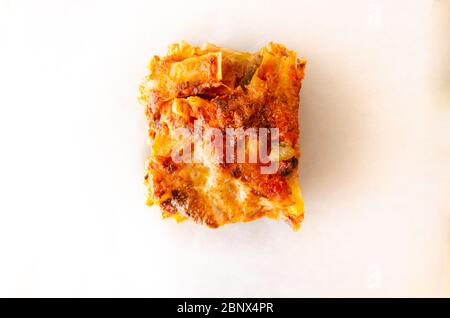 Hand made close up vegetable lasagna on baking cooking paper isolate on white top view Stock Photo