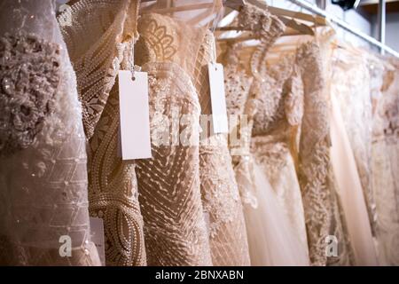 wedding dresses on clothes rail hanging rail Stock Photo