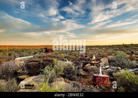 old car wreck under nice clouds in middle of nowhere Stock Photo
