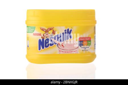 Nesquik milkshake mix product  in a yellow plastic container isolated against a white background with a reflection. Stock Photo
