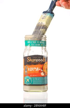 A Sharwoods cooking sauce pot used as a paint brush cleaner container as part of recycling use of products and glass.  isolated on a white background. Stock Photo