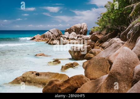 La Digue, Seychelles Islands. Turquoise ocean lagoon at popular Anse Cocos beach with granite rock formations Stock Photo