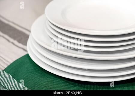 Plates white empty stack on kitchen table. Close up Stock Photo