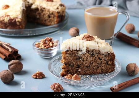 Homemade crumb cake with walnuts and cinnamon in plate on light blue background, ready to eat, horizontal format Stock Photo