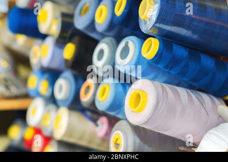 Colored thread on bobbins in a sewing workshop. Garment industry concept Stock Photo