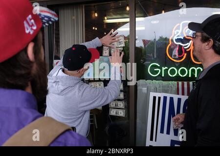 Vancouver, USA. 16th May, 2020. A supporter tapes money to the window of The Pet Biz to help out owner Kelly Carroll who officially opened her business today in Vancouver, Wash., on May 16, 2020. The opening is a direct violation of Governor Jay Inslee's orders for non-essential business to remain closed at this time, but Kelly, who has already been operational for five days, insists she need to open to support her grand-daughters. (Photo by Alex Milan Tracy/Sipa USA) Credit: Sipa USA/Alamy Live News Stock Photo