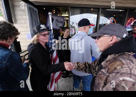 Vancouver, USA. 16th May, 2020. A supporter shakes the hand of Kelly Carroll who officially opened her business, The Pet Biz, a luxury pet grooming operation in Vancouver, Wash., on May 16, 2020. The opening is a direct violation of Governor Jay Inslee's orders for non-essential business to remain closed at this time, but Kelly, who has already been operational for five days, insists she need to open to support her grand-daughters. (Photo by Alex Milan Tracy/Sipa USA) Credit: Sipa USA/Alamy Live News Stock Photo