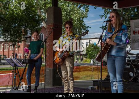 Family band of two sisters and a brother, plaaying in outdoor rock concert. Stock Photo
