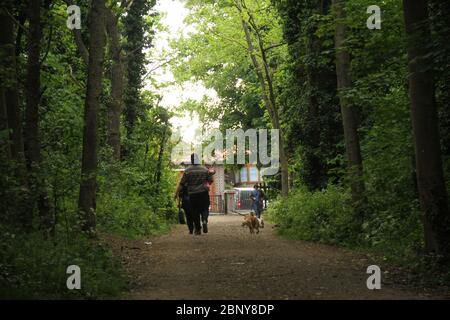London, UK - 16 May 2020: A couple walk through Wanstead park during the London lockdown during the first weekend after the slight ligting of the London Covid19 lockdown.   The government's lockdown in effect since late March, advised the public to stay at home due to the Covid-19 pandemic. Photos: David Mbiyu Stock Photo
