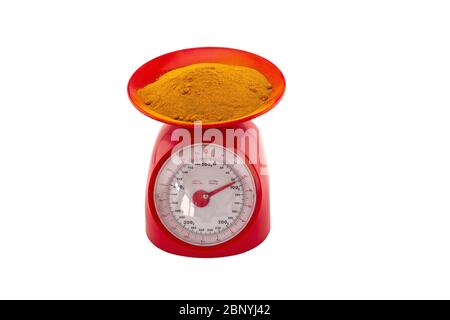 Turmeric  powder in red weight scale on white background Stock Photo