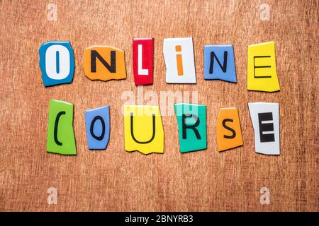 ONLINE COURSE message on wooden background. Online studying. Distant education. Digitizing concept. Form of studying processed by computer. Network Stock Photo