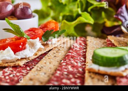 Beetroot and rye flour crackers with vegetables for making snacks on a wooden background. Vegetarianism and healthy eating. Stock Photo