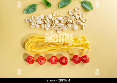 Raw pasta top view and cherry tomatoes, cooking pasta Stock Photo
