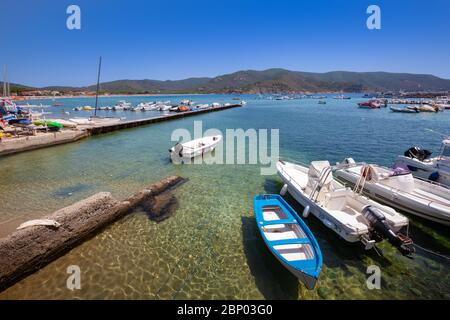 Marina di Campo, Italy. June 25, 2016: Small harbor with boats anchored in the pier in the sea on the Island of Elba. Long quay. Homes, mountains and Stock Photo