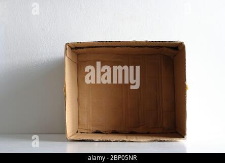 Closeup and selective focus on bottom of an empty cardboard box under sunlight and shadow, box image isolated on white background with copy space Stock Photo
