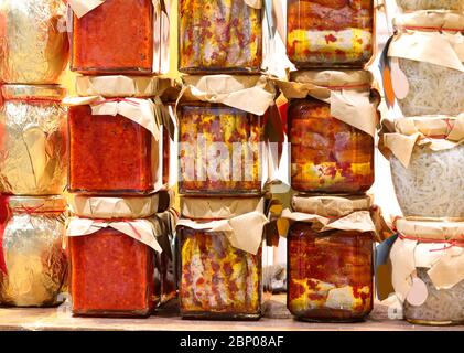 many jars with Southern Italian specialties with anchovies, spicy peppers, onions and cherry tomatoes in oil Stock Photo