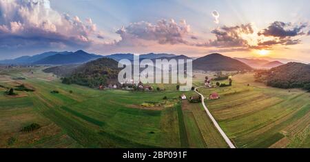 Beautiful sunset in mountains in Croatia. Bird's eye view panorama of amazing sky and the red sun lights shooting clouds over valley. Stock Photo