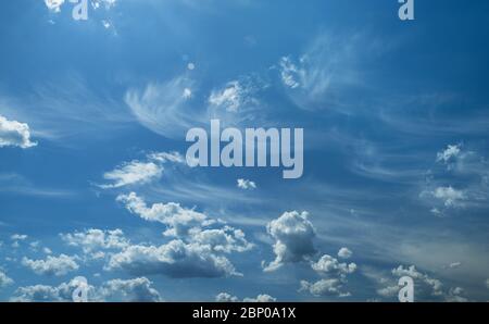 Some light cumuliform and cirrus clouds in the clean blue sky. Nature background. Stock Photo