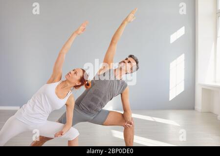 Yoga people in sportswear are practicing yoga in a bright classroom. Stock Photo