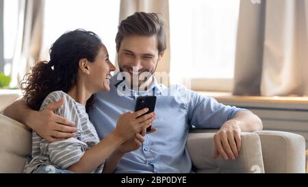 Happy young couple using modern smartphone together Stock Photo