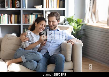 Happy young couple using smartphone at home Stock Photo