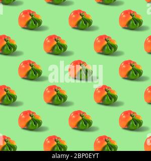Ugly orange pepper seamless pattern peppers on a green background. Stock Photo