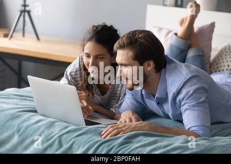 Young couple relax in bedroom using laptop Stock Photo