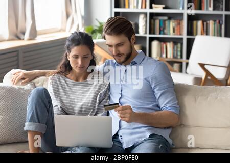 Young couple make payment shopping online on laptop Stock Photo