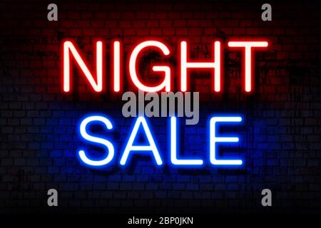 Night sale. Neon sign with luminous letters of red and blue on a black brick wall. Stock Photo