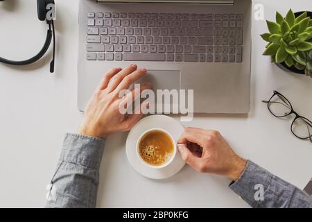 Man working on laptop and drinking coffee Stock Photo