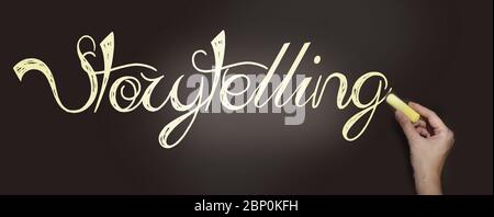 Storytelling words written on blackboard and hand with pale yellow chalk. Copywriting telling story marketing concept Stock Photo