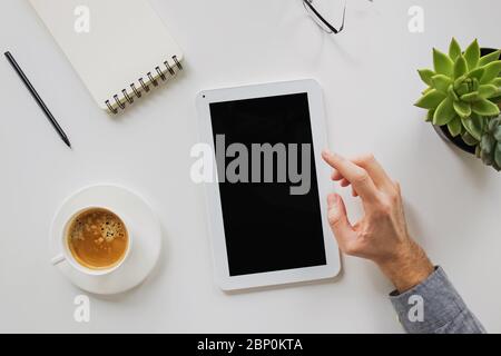 Man working on and drinking coffee at his workplace. Stock Photo