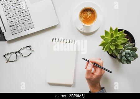 A man is working by using a laptop computer on vintage wooden table. Hand typing on a keyboard. Stock Photo