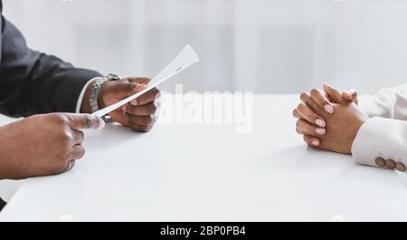 Unrecognizable African American HR manager with resume and female job appicant on employment interview in office Stock Photo