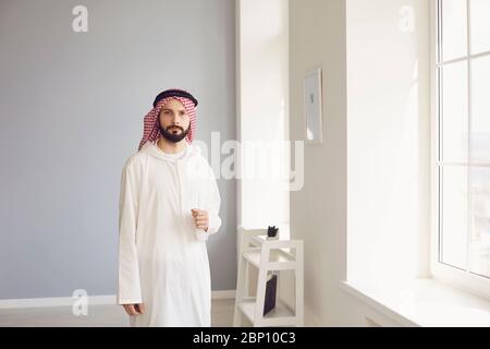 Attractive arab man standing in modern office Stock Photo