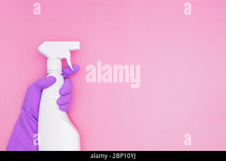 Female hand holding spray with detergent or sanitazer on pink background with copy space Stock Photo
