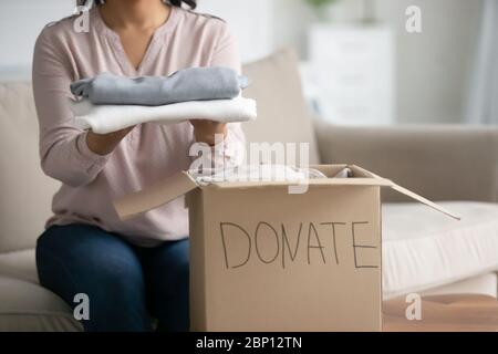 Woman prepared box with old clothes for donation closeup view Stock Photo