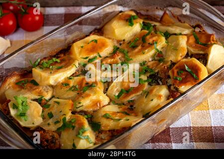 Homemade moussaka with meat, potatoes and herbs in glass tray Stock Photo