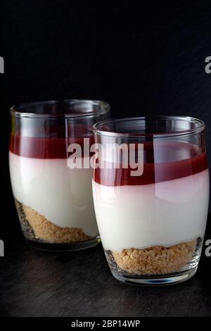 Sweet raspberry dessert in glass over dark slate Stock Photo