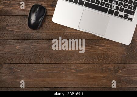 Laptop and mouse on wooden desk. Flat lay shot, working at home concept Stock Photo