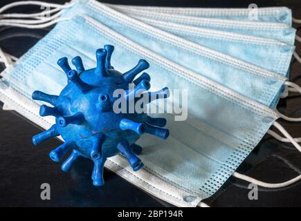 COVID-19 coronavirus or flu concept, model of blue novel SARS-CoV-2 corona virus on medical masks, safety and protection due to coronavirus. Stop spre Stock Photo