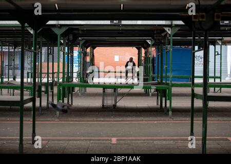 A man sits within the deserted Bullring Open Market in Birmingham, after the introduction of measures to bring the country out of lockdown. Stock Photo