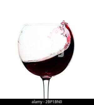 Splash of red wine in a glass isolated on a white background. Stock Photo