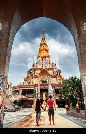 Happy travel couple explore scenery Thai architecture in the Lanna style in Thailand temple. Popular famous landmark travel destination in Thailand.