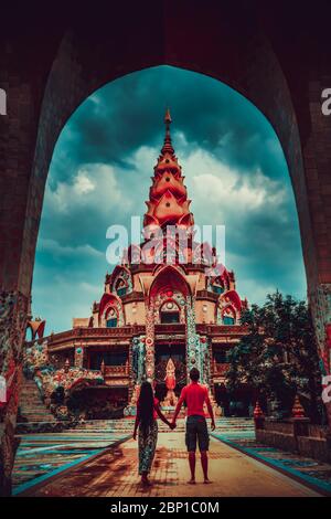 Happy travel couple explore scenery Thai architecture in the Lanna style in buddhist Thailand temple. Asian culture and religion